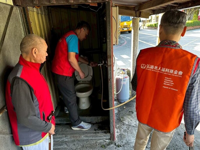 獨居在宜蘭老舊鐵皮屋的56歲阿銘（左）中風多年，屋中熱水器早已壞掉，瓦斯桶也嚴重生鏽，弘道老人福利基金會協助他換熱水器，讓他終於能在寒冬裡再次洗個安全又溫暖的熱水澡。（弘道老人福利基金會提供）中央社記者曾以寧傳真　115年2月6日