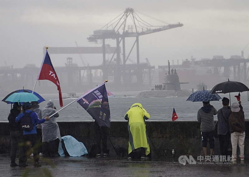 潛艦國造原型艦海鯤艦連續2天進行潛航測試，6日高雄下起陣雨，但仍有軍事迷穿著雨衣、撐雨傘在港邊等候。中央社記者董俊志攝　115年2月6日