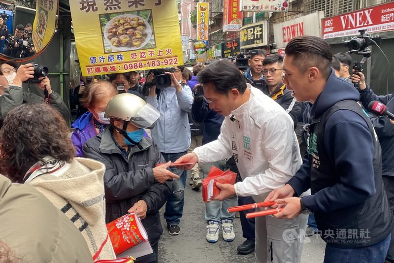 民眾黨主席黃國昌（前右2）7日上午在民眾黨籍新北市議員陳世軒（前右）陪同下，前往新莊區宏泰傳統市場發送春聯、紅包，與攤商互動拜年。黃國昌也逐一彎腰致意、問候新年好。中央社記者黃旭昇新北攝    115年2月7日