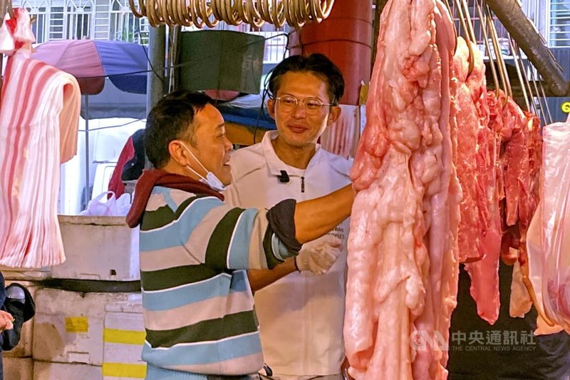 民眾黨主席黃國昌（右）7日在新北市新莊區傳統市場拜票，有豬肉攤商（左）當面要求黃國昌將65歲以上長者補助裝假牙、育兒補助津貼的補助具體金額，列入社會福利政見。中央社記者黃旭昇新北攝    115年2月7日