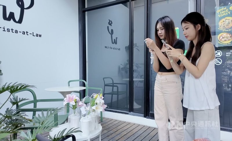 攻讀法律系的大學生查農吉達（左）和皮拉功（右）在校園低頭整理親手插好的花束，準備在情人節前夕拿去販賣。對於即將到來的大選，查農吉達直言「我們需要一個不會貪腐的領導人」。中央社記者李宗憲曼谷攝　115年2月7日