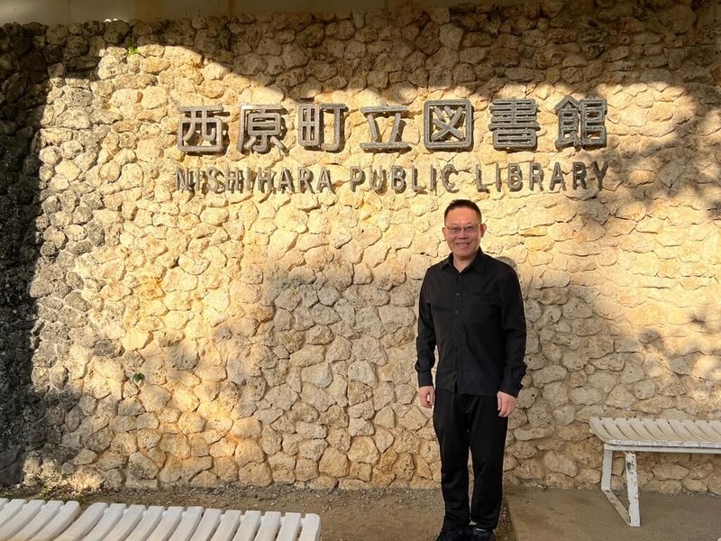 東京大學東洋文化研究所特聘研究員林泉忠最近重訪沖繩，與當地官員、專家學者及媒體人士就中國第三波「琉球熱議」進行交流。他表示，沖繩主流社會對中國再打「琉球牌」出現一定程度的違和感甚至不快。圖為林泉忠攝於沖繩西原町立圖書館。（受訪者提供）中央社記者陳鎧妤傳真  115年2月8日