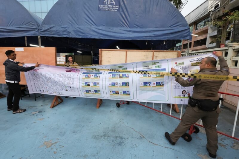 泰國選舉工作人員在投票站前布置大選資訊。（路透社）