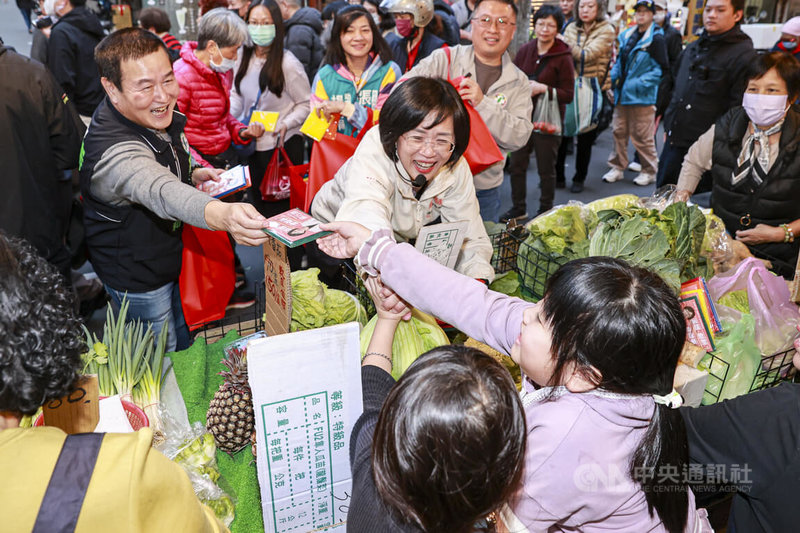 民進黨新北市長參選人蘇巧慧(中)10日傍晚在中和大勇街黃昏市場掃街拜票,向攤商與民眾遞送菜瓜布宣傳品,近距離爭取民眾支持。中央社記者鄭清元攝 115年2月10日