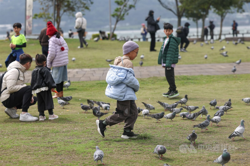 圖為小朋友穿著保暖衣物在淡水河畔嬉戲。（中央社檔案照片）