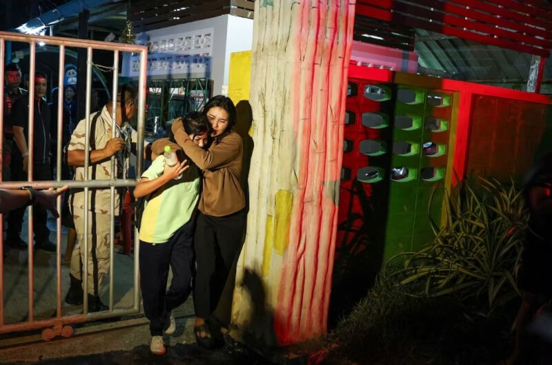 泰國宋卡府合艾一所學校11日發生槍擊案，一名槍手闖入校園開槍。圖為1名女子從校園撤離。（路透社）