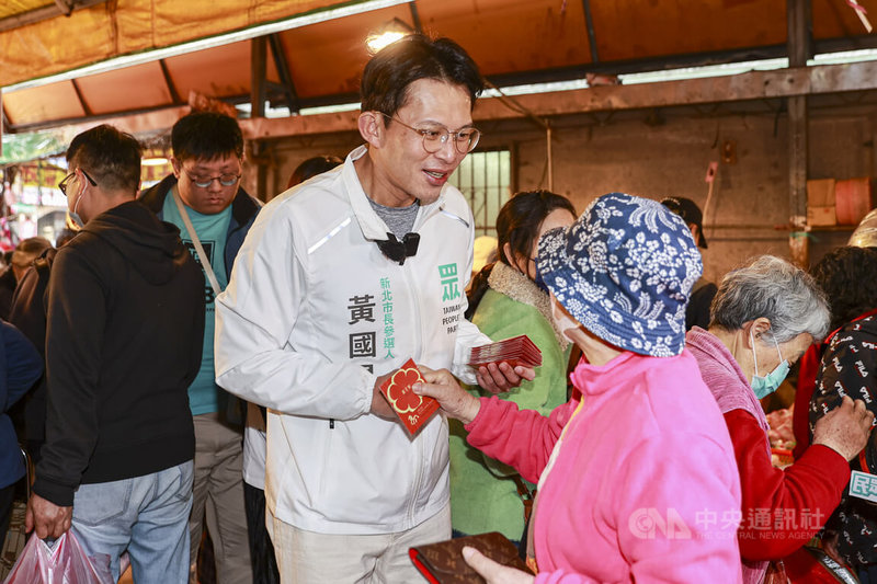 民眾黨新北市長參選人黃國昌（白衣）11日上午前往新店建國、仁愛市場掃街拜票，沿途與攤商、民眾握手致意。中央社記者鄭清元攝　115年2月11日