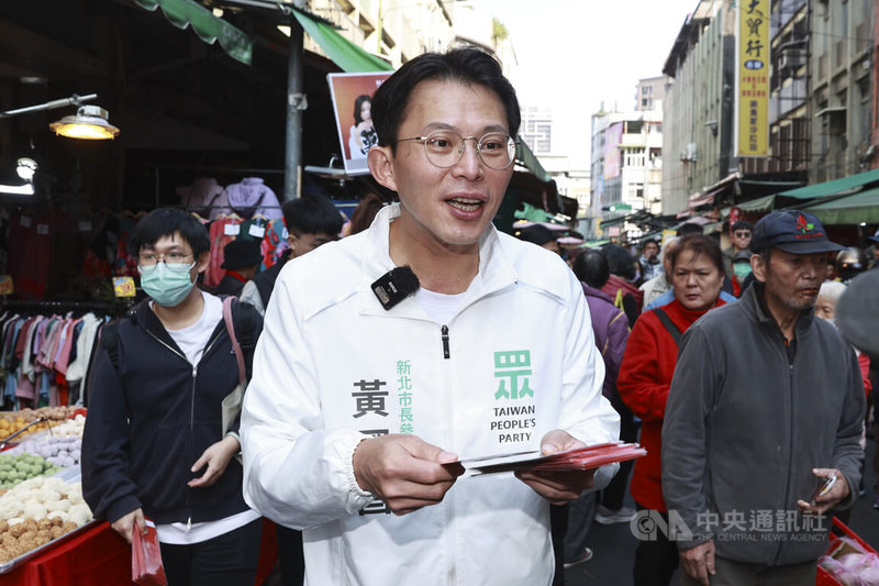 民眾黨新北市長參選人黃國昌（中）12日上午前往板橋福德市場掃街拜票，沿途發放春聯福袋並與攤商民眾握手致意。中央社記者鄭清元攝　115年2月12日