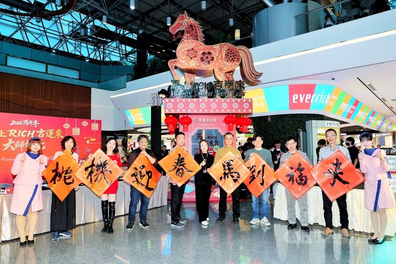 桃園國際機場昇恆昌免稅商店12日邀請日知書學會會長、逢甲大學通識教育中心專任副教授蕭世瓊（前右5）率領書法名家，在二航廈管制區內現場書寫「桃機迎春馬到福來」新年春聯。中央社記者吳睿騏桃園機場攝　115年2月12日