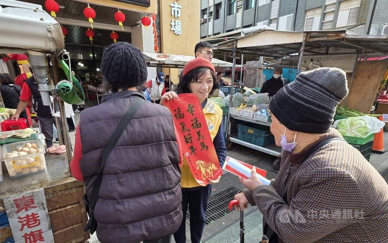 有意投入下屆澎湖立委選舉的台聯黨主席周倪安（中）與競選團隊12日到馬公北辰市場，分送採買民眾「幸福美馬  福氣好年」春聯與紅包袋，採買民眾爭相索取。中央社   115年2月12日