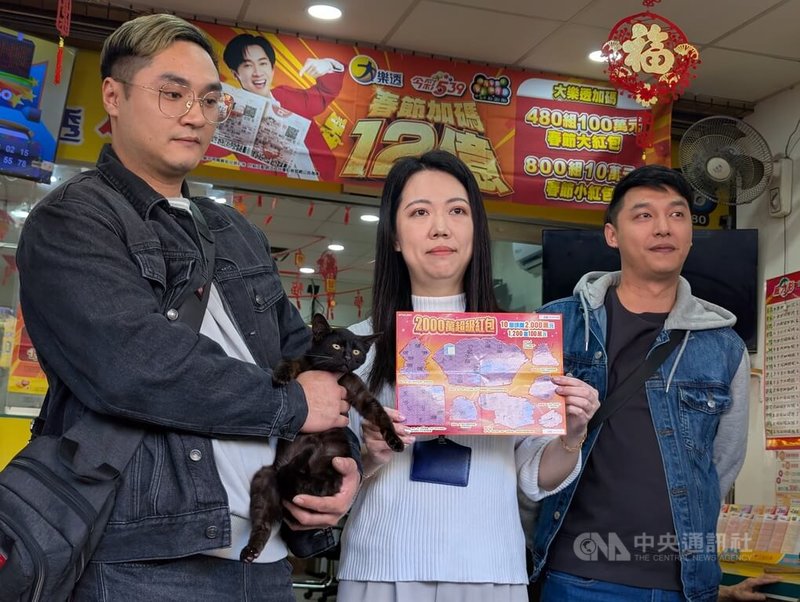 台中陳姓兄弟（左、右）日前認養一隻黑色流浪貓，2人12日帶著黑貓到南區1家彩券行購買刮刮樂，竟刮中新台幣100萬元獎項，13日重回彩券行分享喜悅。中央社記者蘇木春攝　115年2月13日