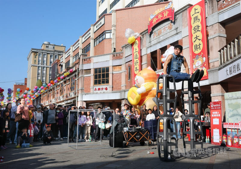 農曆春節將至，圖為民眾在台北市迪化年貨大街觀看街頭藝人表演。（中央社檔案照片）
