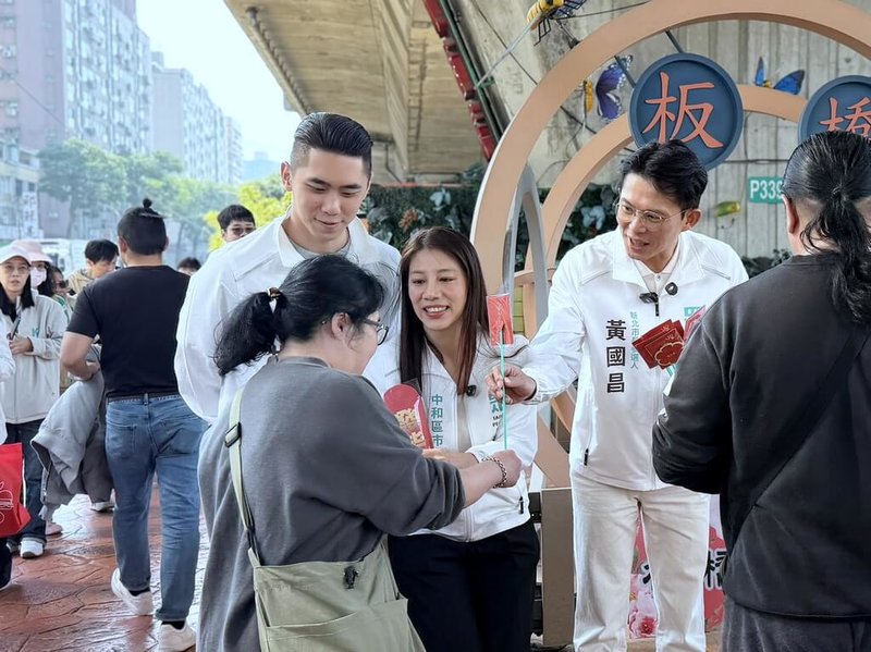 民眾黨新北市長參選人黃國昌（後右）14日在民眾黨新北市議員陳世軒（後左）等人陪同下，在板橋花市向民眾和攤商拜年，並發送限量「心動小物」。（黃國昌辦公室提供）中央社記者黃旭昇新北傳真  115年2月14日