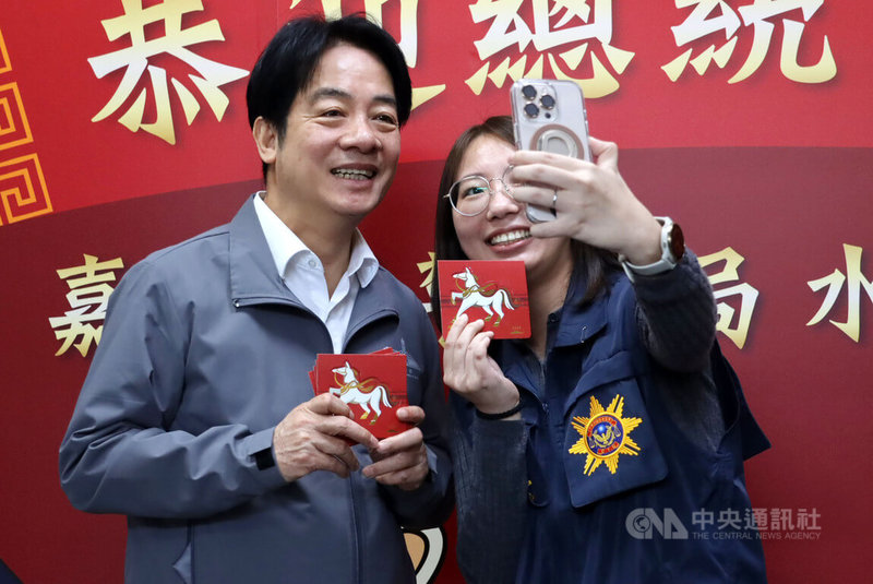 總統賴清德(左)15日至嘉義縣警察局水上分局慰勉警察人員並發送紅包,遇到這難得的機會,員警拿起手機與賴總統自拍合影。中央社記者蔡智明攝 115年2月15日