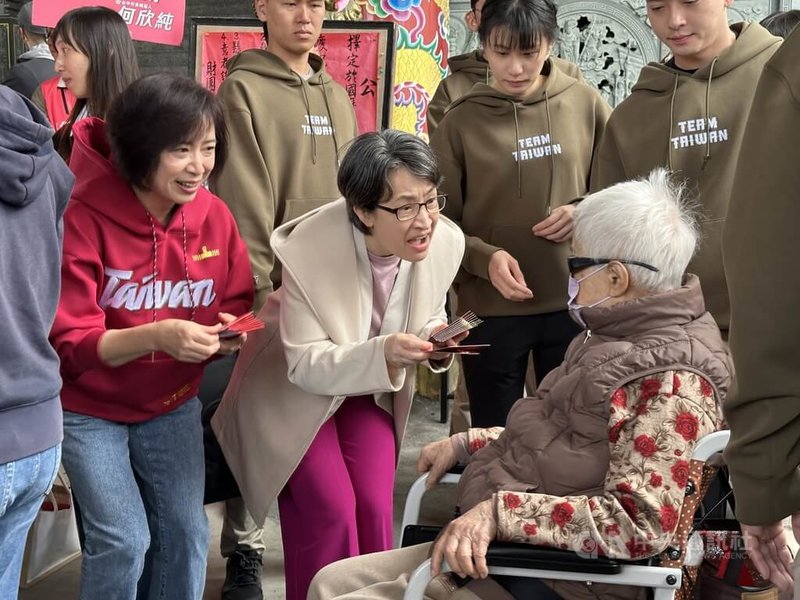 副總統蕭美琴(右2)大年初一,南下台中市霧峰區南天宮發放馬年福袋,遇到行動不便長者,蕭副總統彎腰發送。中央社記者趙麗妍攝 115年2月17日
