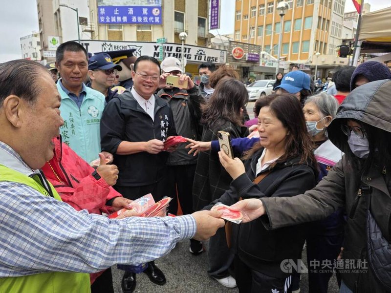澎湖縣長陳光復（左）與馬公市長黃健忠（左3）等人，17日前往馬公城隍廟市集，除向走春的民眾賀年外，也發放馬年「百福具臻」福袋與馬運亨通紅包袋，民眾爭相索取。中央社  115年2月17日