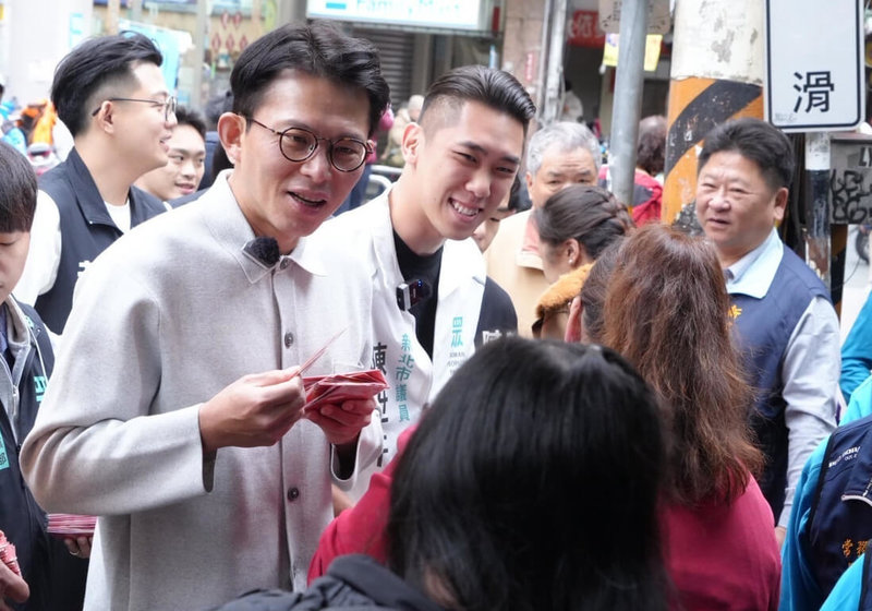 民眾黨新北市長參選人黃國昌（前左）17日與同黨議員陳世軒（後中）赴新莊武聖廟參拜、發放福袋，受訪時透露兩人已有通話，對於新北未來的願景、想法，彼此都敞開心胸交換意見。（民眾黨提供）中央社記者曹亞沿傳真　115年2月17日