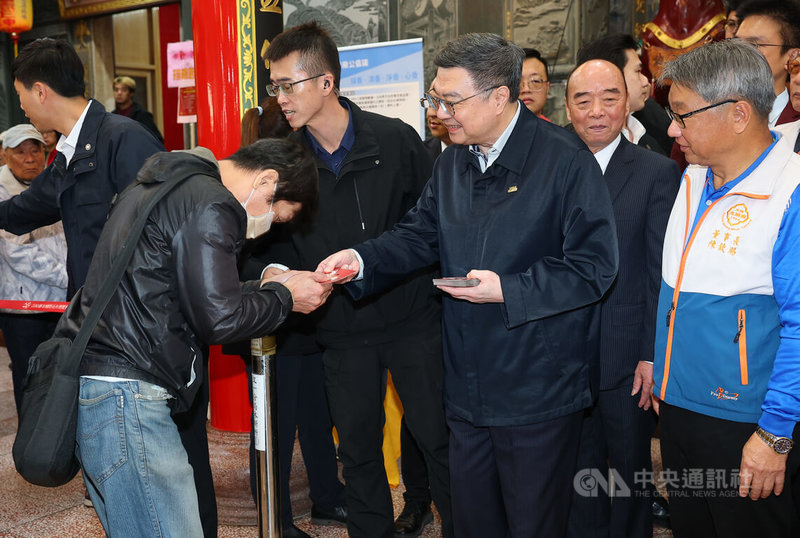 行政院長卓榮泰(前右2)17日上午前往木柵忠順廟參拜祈福,並發放福袋給現場排隊領取的民眾。中央社記者謝佳璋攝 115年2月17日