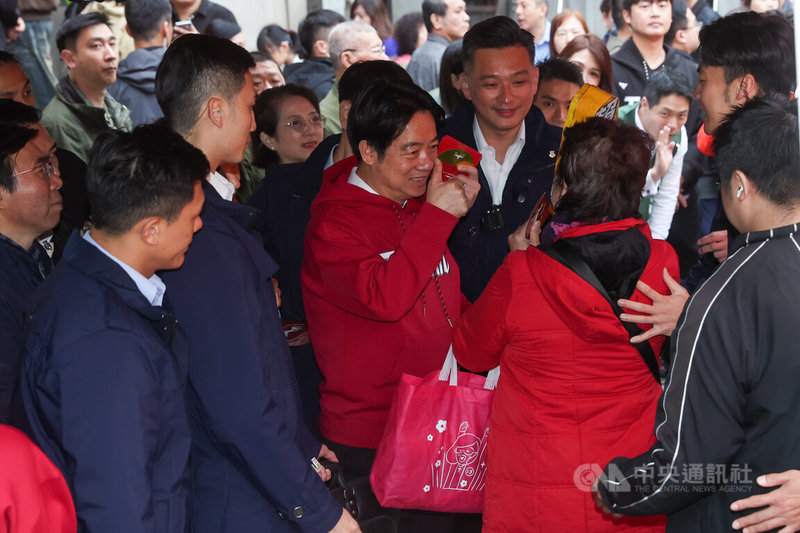 總統賴清德（中紅衣者）17日上午在艋舺龍山寺參香並發放福袋，賴總統發放福袋給民眾，並比讚祝福民眾新年快樂。中央社記者吳家昇攝 115年2月17日