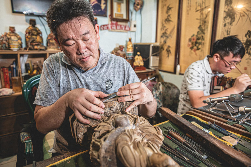 神像修復師金明偉（左）人稱「阿寶師」，2021年獲新北市登錄文化資產保存技術「神像修復」保存者，執業30餘年至今已經手上萬尊神像。（台北霞海城隍廟提供）中央社記者王寶兒傳真　115年2月18日