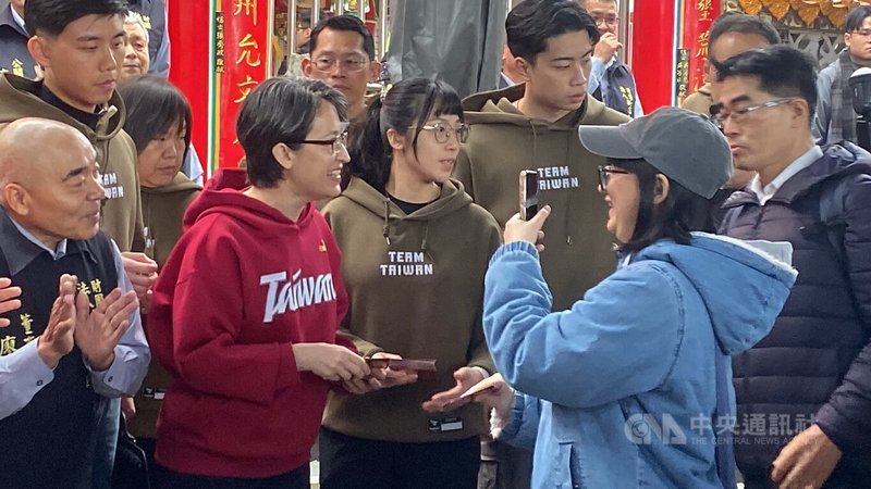 副總統蕭美琴（前左2）18日到新北市新店區太平宮走春祈福，在廟前廣場發福袋，吸引民眾排隊領取，有人開心拿手機搶拍留念。中央社記者黃旭昇攝　115年2月18日