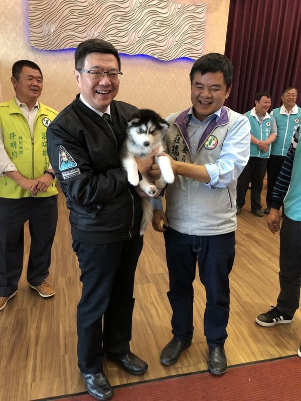 民進黨立委莊瑞雄多年前母親過世，為了幫父親找個伴，領養了「4狗1貓」為家中、服務處、國會辦公室增添滿滿的人氣，柴犬TORO可愛的模樣，時任民進黨主席、現任行政院長卓榮泰抱在懷裡笑開懷。（立委莊瑞雄國會辦公室提供）中央社記者溫貴香傳真　115年2月18日