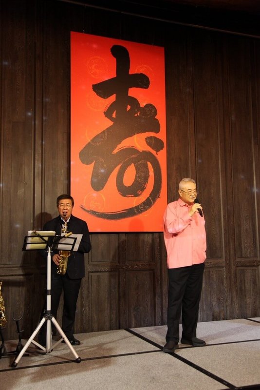 李國鼎基金會董事長王伯元(右)祖籍蘇州,他不諳台語,深感溝通受限,經高人指點「學台語的捷徑就是唱台語歌」,自此開啟他的唱歌魂。他更把80歲生日壽宴變成個人演唱會。(王伯元提供)中央社記者潘智義傳真 115年2月19日