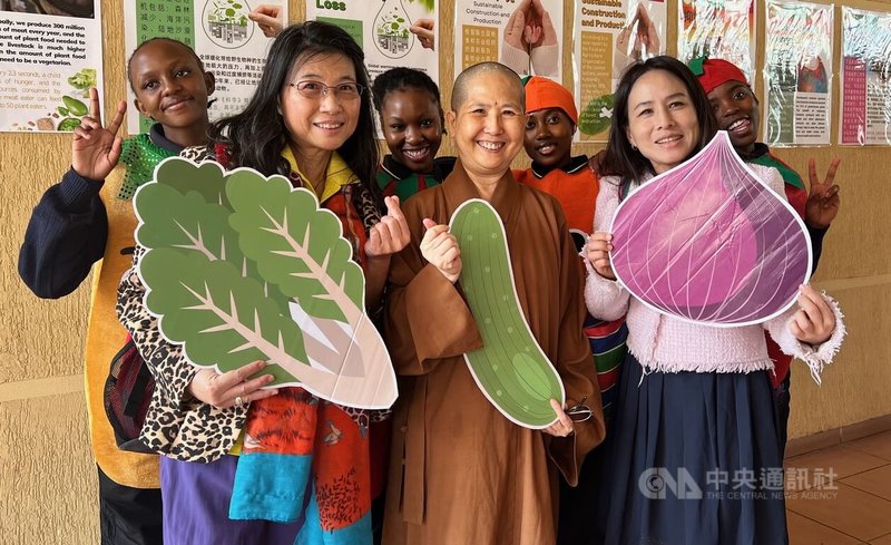 南非佛光山南華寺新春期間舉辦蔬食品嘗會，覺諦法師（前排中）與當地青年手持蔬菜造型道具合影，倡議蔬食永續與愛護生命理念。中央社記者李依璇布朗浩斯普特攝　115年2月20日