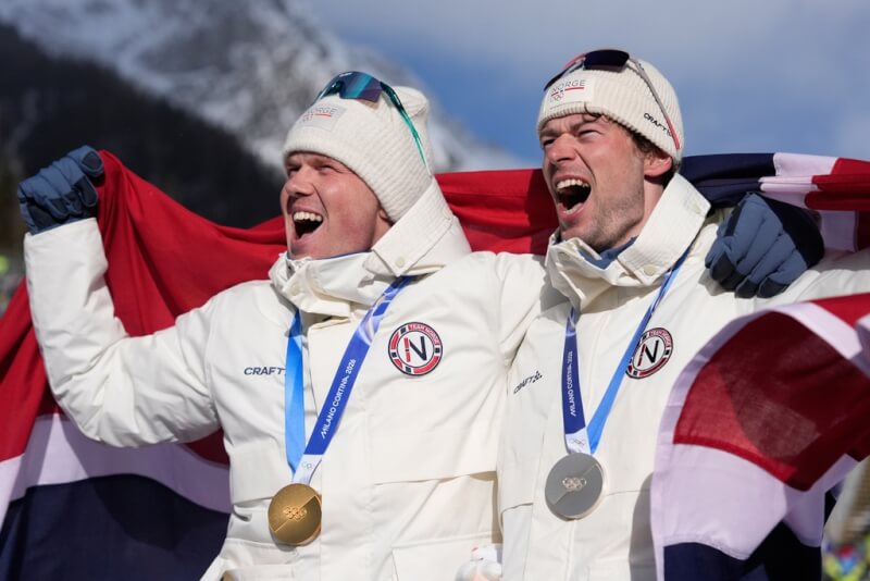 挪威選手戴爾-斯凱夫達爾（左）21日在冬季奧運15公里集體出發越野滑雪射擊賽中奪金。圖為戴爾-斯凱夫達爾和拿下銀牌的隊友萊格雷德（右）站上頒獎台。（美聯社）