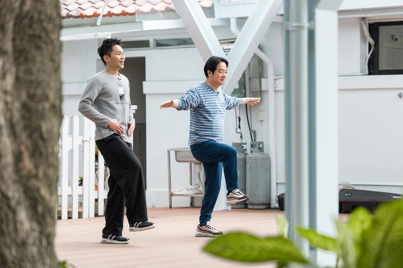 總統賴清德(右)與運動部長李洋(左)一同示範居家健康操,從暖身、伸展、深蹲、單腳站立等動作,訓練身體的活動度、平衡感與核心肌群。(總統府提供)中央社記者溫貴香傳真 115年2月21日