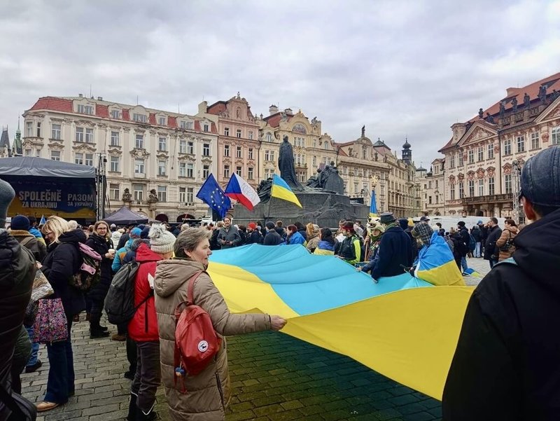 俄羅斯入侵烏克蘭將滿4年，數百人21日在布拉格舊城廣場參加「共同為烏克蘭！」集會。現場多位參與者共同拉著大型烏克蘭國旗布條。　（民眾提供）中央社記者劉郁葶布拉格傳真　115年2月22日