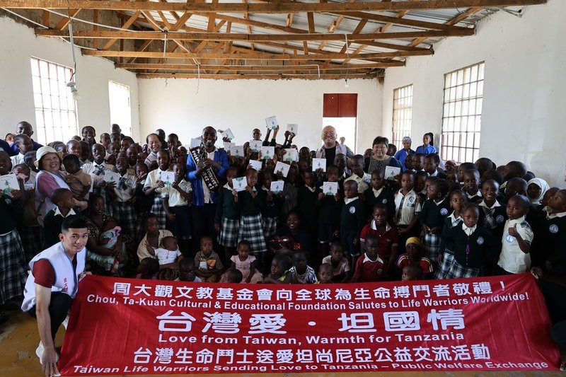 周大觀文教基金會創辦人周進華與董事長郭盈蘭率台灣生命鬥士一行，13日在坦尚尼亞穆宛沙Soma Bags社會企業與當地學童合影。當日並與穆宛沙華僑代表王瀋虹合頒「全球熱愛生命獎章」予社會企業創辦人伊諾森特．詹姆士（Innocent James）。（周大觀文教基金會提供）中央社記者李依璇約翰尼斯堡傳真　115年2月22日