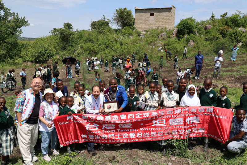 周大觀基金會13日赴坦尚尼亞頒發全球熱愛生命獎章予社會企業創辦人伊諾森特.詹姆士(Innocent James)。詹姆士受周大觀遺作「我還有一隻腳」中「種樹」一文感動,號召現場志工與學童種下樹苗,象徵為希望與教育扎根。(周大觀文教基金會提供)中央社記者李依璇約翰尼斯堡傳真 115年2月22日