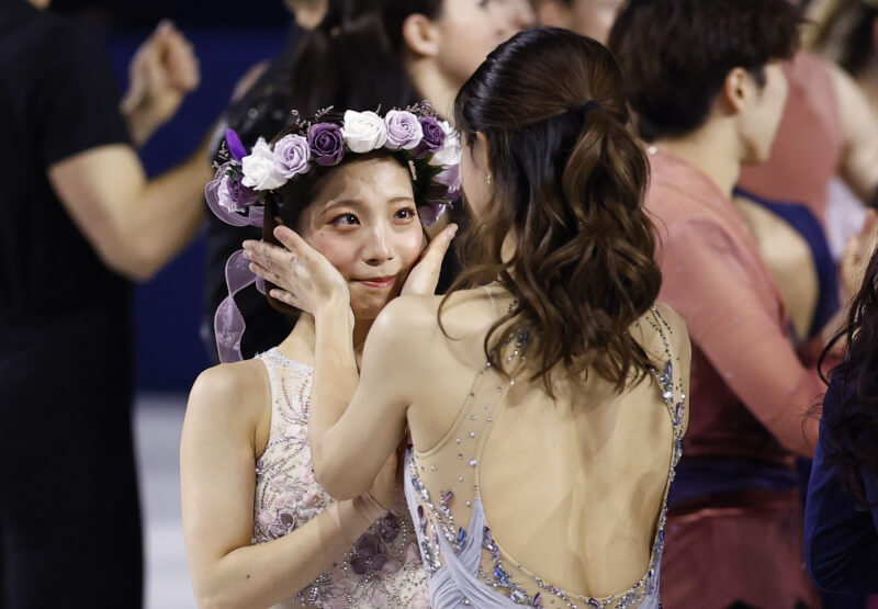 坂本花織(右)為三浦璃來(左)戴上花圈頭飾。(共同社)