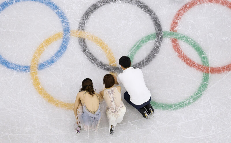 三浦璃來(中)、木原龍一(右)和坂本花織(左)一同鞠躬、觸摸冰面向賽場致意。(共同社)