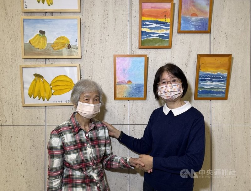 超高齡社會到來，台大北護分院24日舉辦失智長者藝術作品，創作者之一陳奶奶（左）與女兒余小姐一起在作品前合影。中央社記者沈佩瑤攝　115年2月24日