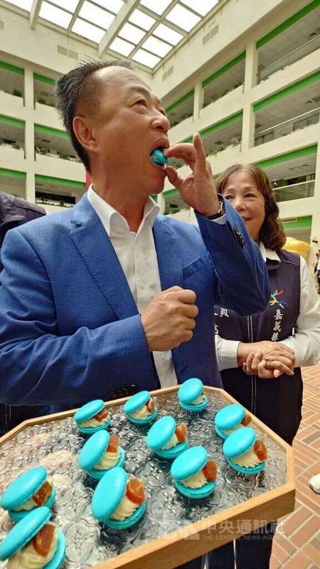 嘉義縣長翁章梁24日出席2026台灣燈會「光躍台灣．點亮嘉義」宣傳記者會，表示現場設有傳統美食市集，邀遊客品嚐嘉義的美食。圖為翁章梁品嚐「烏魚子馬卡龍」。中央社記者蔡智明攝　115年2月24日
