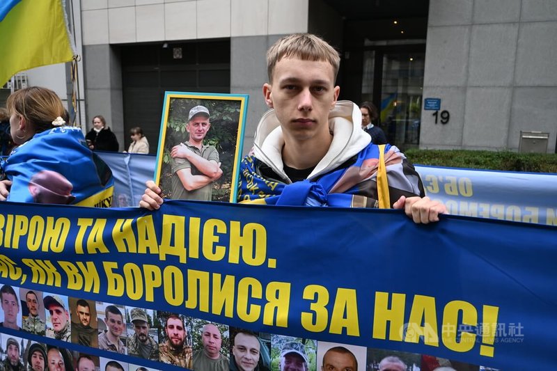 俄烏戰爭屆滿4年，百餘名民眾24日在布魯塞爾的歐洲議會周邊遊行，許多人舉著陣亡或是失蹤的烏克蘭士兵照片。中央社記者吳柏緯布魯塞爾攝 115年2月25日