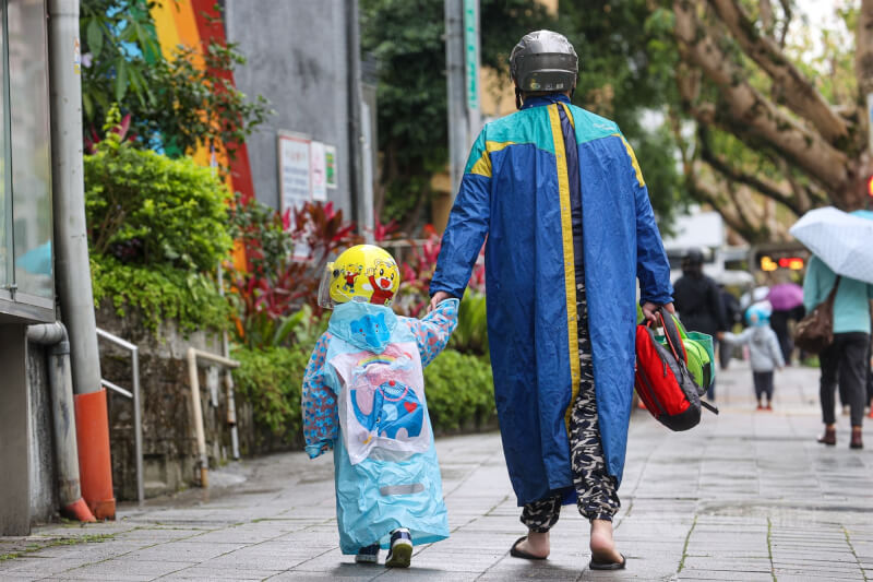 台北市政府推出「育兒減少工時計畫」3月上路，供12歲以下子女確有親自接送需求的家長減少1小時工時。圖為台北市文山區家長接送孩子上幼兒園。（中央社檔案照片）