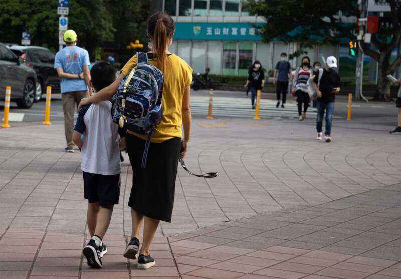 台北市宣布推動「育兒減少工時」試辦計畫，家有12歲以下孩子的家長減少工時1小時。圖為台北市松山區一間國小外家長接送孩子。（中央社檔案照片）