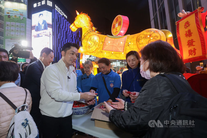 台北市長蔣萬安（前左）26日晚間在西門町紅樓前廣場出席「2026台北燈節」西門展區點燈儀式，並到「松山慈惠堂」燈區前幫忙發送錢母。中央社記者裴禛攝　115年2月26日