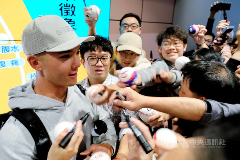 效力美國職棒大聯盟克里夫蘭守護者隊的台美混血好手費柴德（Stuart Fairchild）（左）26日晚間搭機抵台，受到大批球迷熱情迎接，費柴德也親切為球迷簽名。中央社記者吳睿騏桃園機場攝　115年2月26日