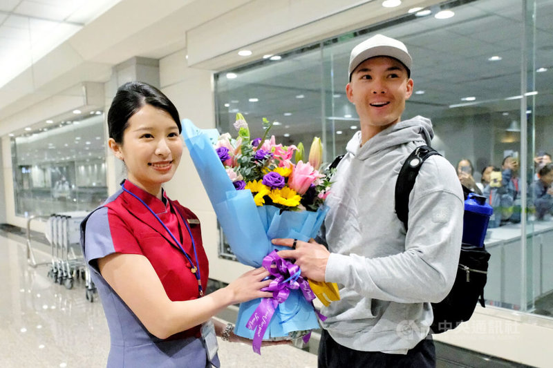 台美混血棒球好手費柴德（Stuart Fairchild）（右）26日晚間搭機順利抵達桃園國際機場，27日就會參與經典賽台灣隊練球，華航地勤人員在機場獻花表達歡迎之意。中央社記者吳睿騏桃園機場攝　115年2月26日