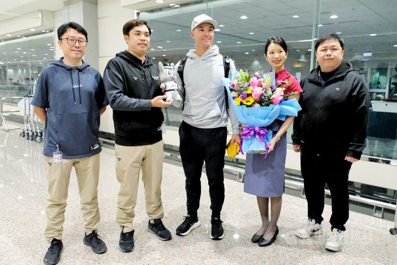 目前效力美國職棒大聯盟克里夫蘭守護者隊的台美混血好手費柴德（Stuart Fairchild）（中）26日晚間搭機抵台，將投入經典賽台灣隊，中職也派員赴機場迎接。中央社記者吳睿騏桃園機場攝　115年2月26日