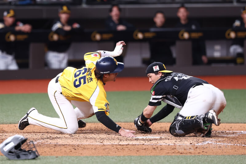 台日棒球國際交流賽25日在台北大巨蛋開打，由日本職棒福岡軟銀鷹對上中華職棒中信兄弟，兄弟隊5局攻勢再起，高宇杰（左）在奔回本壘的過程中，技巧性閃過對手順利得分。中央社記者王騰毅攝　115年2月25日