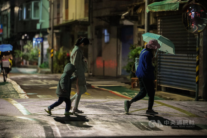 228連假來臨，中央氣象署指出，受華南雲雨區東移及東北季風影響，28日各地都有機會降雨，北部較涼，整天氣溫約攝氏17至21度。圖為台北市內湖區27日晚間飄起小雨，民眾快步前行。中央社記者翁睿坤攝　115年2月27日