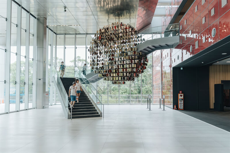 國家檔案館2樓往3樓的螺旋梯上設置公共藝術「以史為鏡」，使用1705片鏡面不鏽鋼，構築直徑達6公尺的巨型立體圓鏡，鏡面背面印製過往36個主題檔案特展的精選檔案，象徵從歷史中照見現在與未來。（國發會檔案局提供）