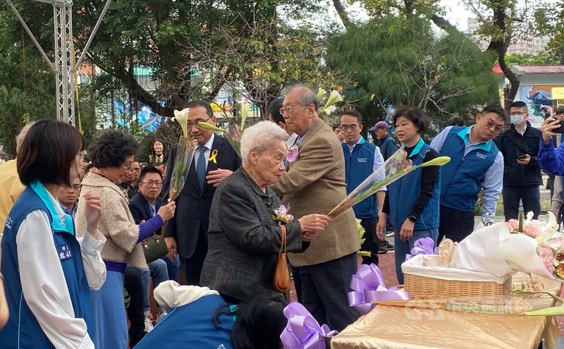 新北市228事件79週年追思紀念儀式28日下午在三重區228和平公園舉行，受難者王瑞國遺孀周金桂（前中持花者）在紀念碑前獻花致意。中央社記者黃旭昇攝　115年2月28日