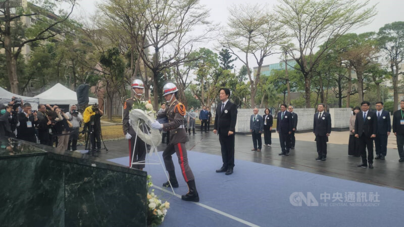 總統賴清德（中）28日南下高雄出席228事件中樞紀念儀式，結束後冒雨步行至會場對面的228和平紀念公園獻花致意。中央社記者洪學廣攝　115年2月28日