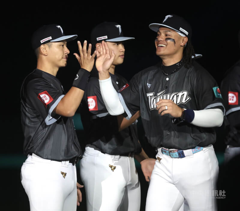 世界棒球經典賽（WBC）台灣隊27日在台日國際棒球交流賽與日本職棒北海道日本火腿鬥士隊交手，台灣隊張育成（右）賽前跟隊友擊掌。（中央社檔案照片）